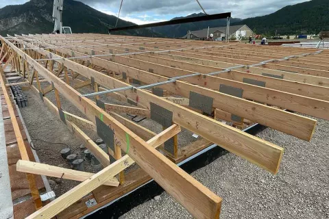 Detail of engineered floor trusses at the Alpine Hotel showing dimensional lumber, metal gusset plates, and lateral bracing across the deck framing