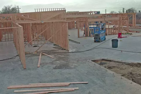 Interior framing progress with scissor lift showing structural walls and beams at IDOC Re-entry Center