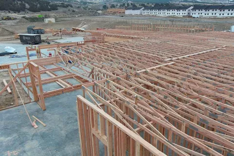 Roof truss system installed across IDOC Re-entry Center with adjacent housing units visible in background