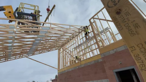 BLU-D framing setting trusses with boom lift and rigging on Hibbard Elementary