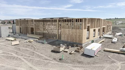 Exterior timber framing with partial wall sheathing and blue sky. 