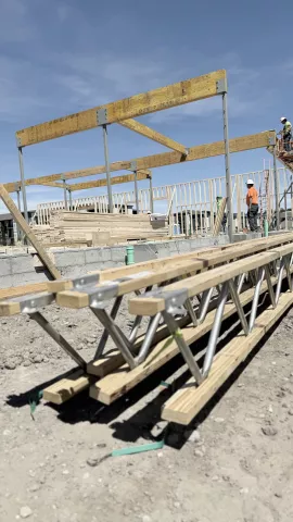 Set glulam beams with trusses on ground.