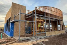 Curved arc framing detail at AFCU Rexburg — vertical wood framing members defining the architectural arc atop the building's second-story volume, integrated with structural steel