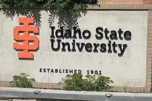Idaho State University monument sign with the orange "ISU" mark and "Established 1901" lettering on a weathered concrete wall