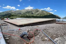 Completed wood deck system at the Alpine Hotel built atop engineered floor trusses, with electrical conduit staged in the foreground and the Snake River Range behind