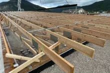 Detail of engineered floor trusses at the Alpine Hotel showing dimensional lumber, metal gusset plates, and lateral bracing across the deck framing