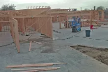 Interior framing progress with scissor lift showing structural walls and beams at IDOC Re-entry Center