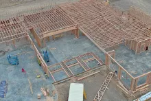 Aerial view of completed roof trusses and wall framing on multiple sections of IDOC Re-entry Center
