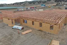 Completed exterior framing and roof truss installation on IDOC Re-entry Center building with mountain backdrop