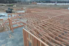 Roof truss system installed across IDOC Re-entry Center with adjacent housing units visible in background