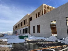 BLU-D Framing exterior view with fully timber framed second floor on top of a masonry based first floor at Alpine Academy