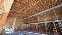 The long trussed roof inside the Island Park Adventure Lodge, framed walls and a fireplace chase below