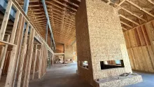 A framed and sheathed fireplace chase inside the Island Park Adventure Lodge, under the roof trusses