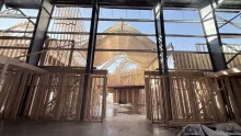 Inside the Playmill Theater: wood-framed walls inside the steel building, the trussed gables seen through the glazing