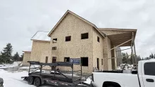 Two-story gable at the Playmill Theater, sheathed and framed for windows, with a BLU-D trailer on site
