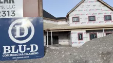 BLU-D Commercial Framing sign in front of the Playmill Theater, its walls wrapped and windows in