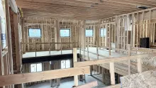 Framed upper level of the Playmill Theater, looking across an open floor to the windows