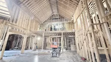 Tall wood-framed hall inside the Playmill Theater, a framed loft under the vaulted roof