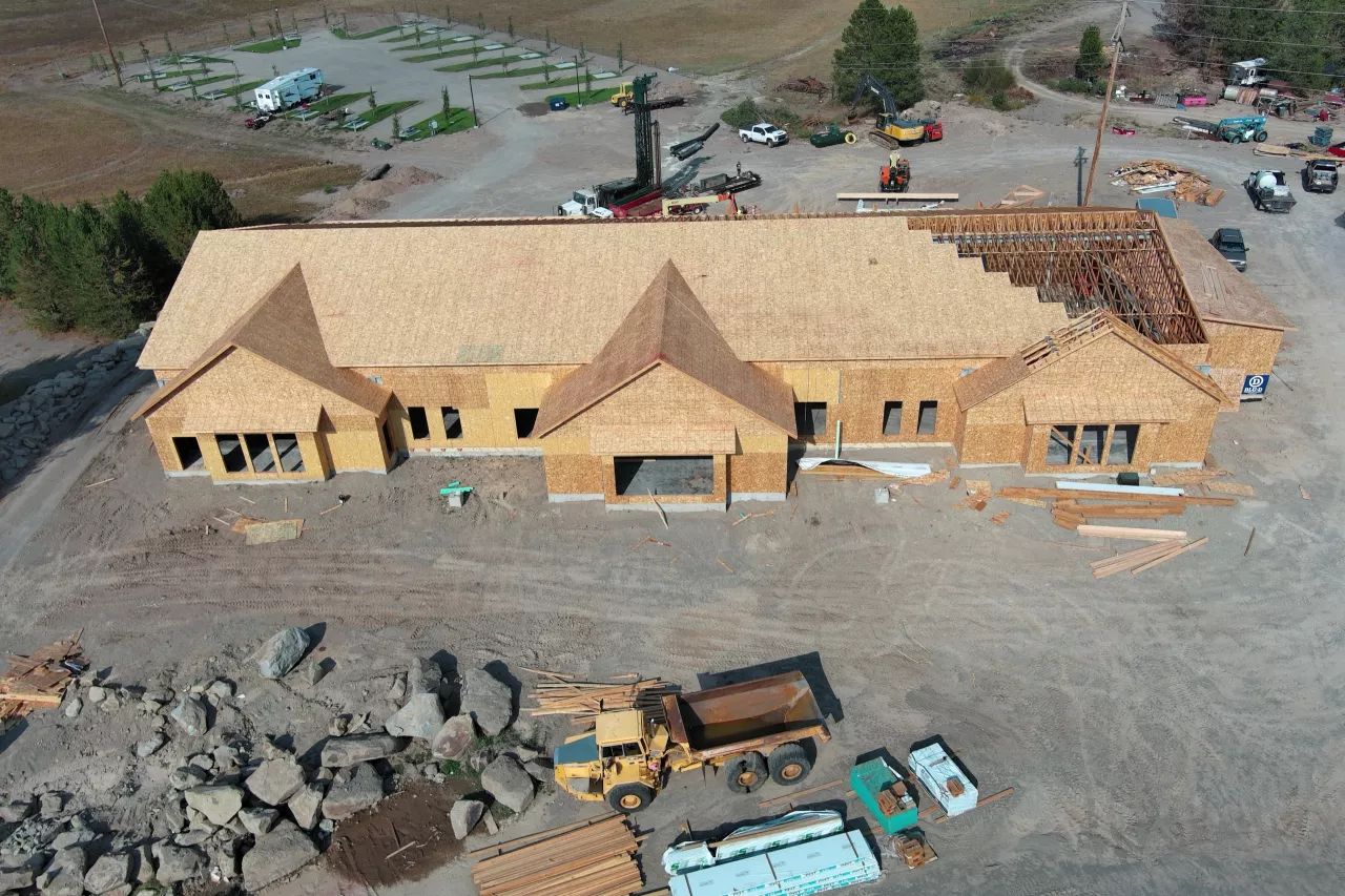 Aerial view over the Island Park Adventure Lodge site, the sheathed roof with its last trusses being set