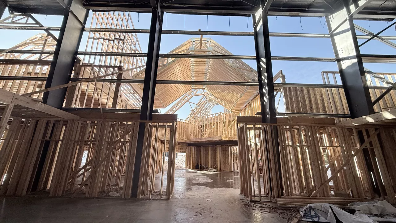 Inside the Playmill Theater: wood-framed walls inside the steel building, the trussed gables seen through the glazing